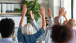 © Kateryna - Diverse group of professionals engaging in a team-building exercise A lively group of diverse individuals, with hands raised high, enthusiastically participates in a team-building