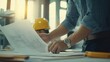 © Adi - Close up of civil male engineer asian working on blueprint architectural project at construction site at desk in office
