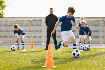 Wall Mural - Soccer Education for Young Boys. Physical Education Class for School Children. Young Coach With Kids in Team on Training Unit. Youth Team Coach Training School Boys in Football Soccer