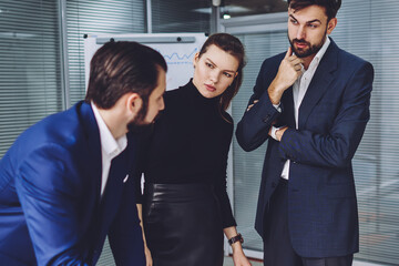 Collaborative process of business partners on common corporate project, male and female entrepreneurs in formal wear discussing graphic sketches and cooperative plan during meeting in office