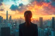 © Minerva Studio - Businesswoman looking at city skyline at sunset