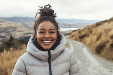 Canvas Print - Happy young woman wearing a down jacket portrait laughing outdoors.