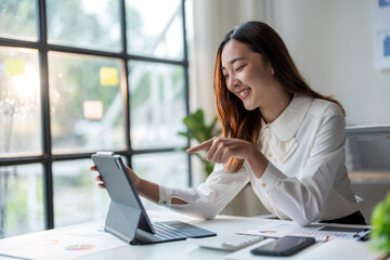 Wall Mural - asian businesswoman working with tablet and smiling at office