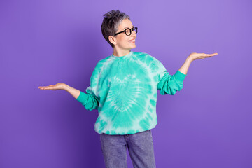 Canvas Print - Photo portrait of pretty retired female compare hold look empty space wear trendy green outfit isolated on violet color background