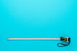 © Ruslan Grumble - Flat lay image of construction measuring tape. Top view minimalist photo of tape measure on turquoise blue background with copy space.