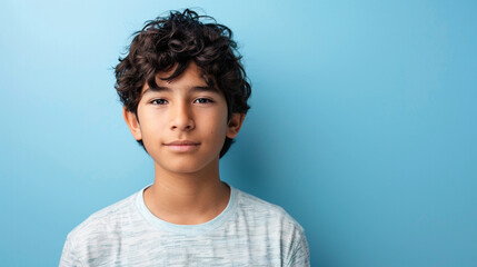 Wall Mural - Portrait headshot of latino hispanic teenager boy on light blue background