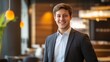 © Plaifah - Confident Young Businessman in Modern Office Setting