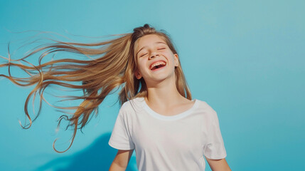 Wall Mural - Teen girl with white T-shirt on a blue background dancing and having fun