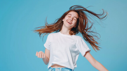 Wall Mural - Teen girl with white T-shirt on a blue background dancing and having fun