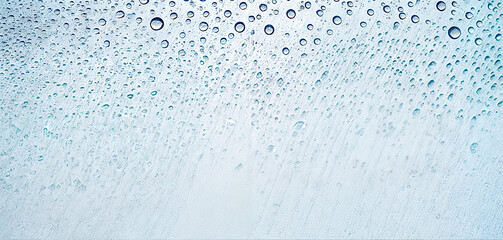 Poster - Raindrops decorate a transparent glass surface, reflecting light and creating a calming visual effect. The view is tranquil and peaceful, perfect for relaxation