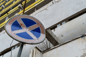 old road sign no stop allowed on the background of an abandoned building
