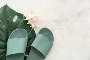 Wall Mural - Pair of green flip flops with seashell and tropical leaf on white background