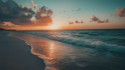 Wall Mural - Sunset over a tranquil ocean with waves gently lapping on the sandy shore.