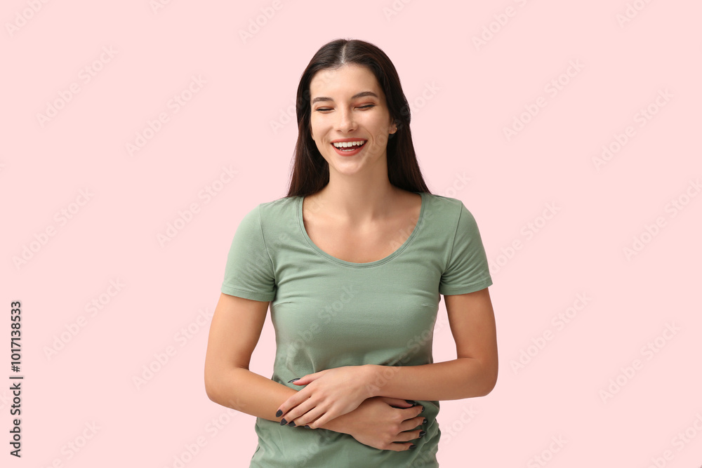 Beautiful happy young woman laughing on pink background