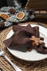 Canvas Print - Christmas place setting with napkin, plate, cutlery and festive decor on table, closeup