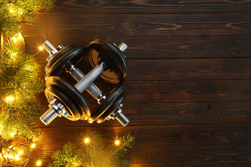 Wall Mural - Dumbbells, fir tree branches and Christmas lights on wooden table, flat lay. Space for text