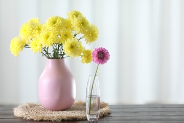 Wall Mural - Beautiful yellow flowers in vases on wooden table at home. Space for text