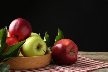 Poster - Ripe apples and green leaves on wooden table. Space for text