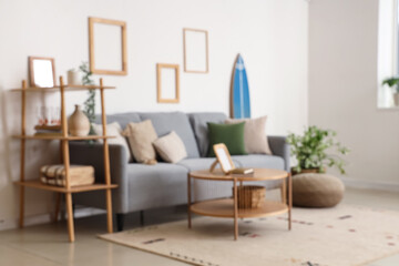 Sticker - Modern comfortable interior of living room with soft sofa and table, blurred view