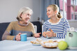 © JackF - Positive mature woman and her adult daughter, who came to visit her, drink tea and chat, telling the latest news