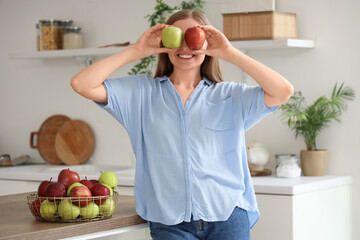 Canvas Print - Young woman with apples in kitchen