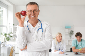 Canvas Print - Male doctor with apple in clinic