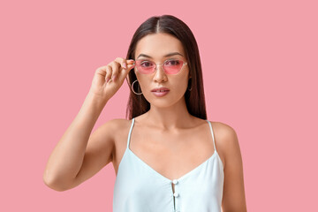 Sticker - Beautiful young Asian woman with stylish mint makeup in sunglasses on pink background