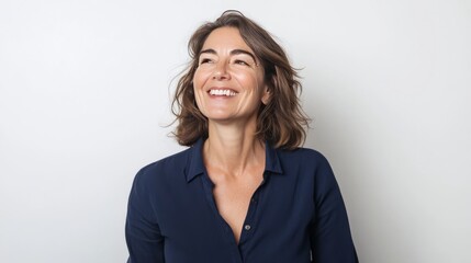 Beautiful senior woman in navy shirt smiles sideways.