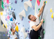 © JackF - Young man in sportswear practicing rock climbing on climbing wall