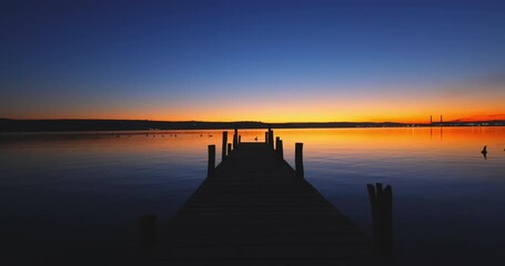 Wall Mural - scenic color sea sunset over wooden fishing pier and ripple water video
