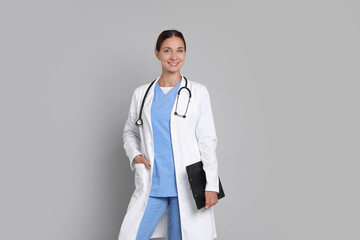 Poster - Nurse in medical uniform with stethoscope and clipboard on grey background