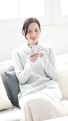 Poster - スマホをタップする冬のニットを着た考える女性のスマホを手に持つ縦動画