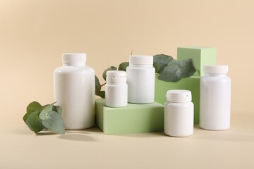 Poster - Plastic medical bottles, eucalyptus leaves and podiums on beige background