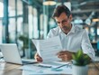 © Phoenix AI Photo - Focused businessman reviewing documents at a modern office desk with a laptop and plant.
