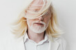 © SHOTPRIME STUDIO - portrait, white background, stylish man with long white hair, soft expression, contemporary fashion, modern aesthetic, light colors, serene vibe, minimalist look, seasonal fashion trends