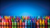 A colorful array of wax crayons, arranged in a staggered formation, stand out against a vivid blue background, capturing the essence of artistic expression and childhood creativity.