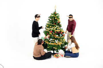 Group of Asian and African friends decorating Christmas tree together, capturing the festive spirit in a warm white background scene of joy, togetherness, and cultural diversity