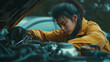 © SB4 GM - A woman fixing her car engine, showing self-reliance and practical skills, with confidence