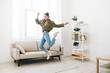 © SHOTPRIME STUDIO - Jumping for Joy: A Happy Woman Dancing and Singing in her Playful Modern Apartment