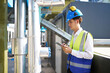 © offsuperphoto - Technician checking pipeline valves or water tank area at urban industrial site