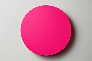 Pink circle on white surface, surrounded by colorful geometric shapes. Bright and playful composition.