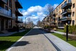 © Sanchai - Realistic image of a newly developed urban district with wide sidewalks, green spaces, and public seating areas, symbolizing the importance of walkability in urban planning