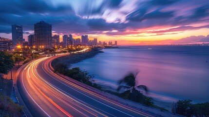 Aufkleber - Highway with city skyline and sea view, a panoramic photo of an empty highway road at sunset with blurred light trails over an island cityscape overlooking the ocean in the background.