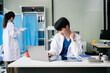 © Nuttapong punna - Doctor analyzing patient data on tablet in clinical lab. Medical professional in hospital with laptop, blood samples