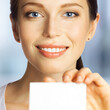 © vgstudio - Portrait of smiling beautiful brunette woman showing advertising white blank mockup mock up empty businesscard plastic credit card, with ad text area, isolated office background. Square image.