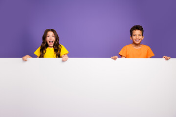 Canvas Print - Photo of charming two little children excited white empty space banner wear trendy orange yellow outfit isolated on violet color background