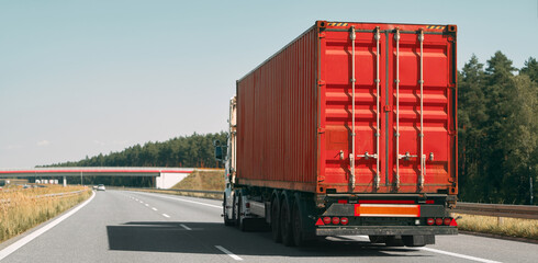 Freight truck with red container on highway