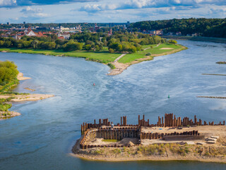 Construction site of new modern bridge construction in Kaunas, Lithuania. Aerial drone view of bridge connecting two shores of a river. Work progress