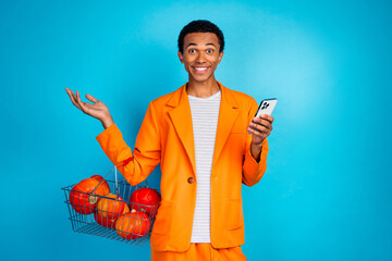 Canvas Print - Photo of positive guy use cellphone for order basket with pumpkin grocery thanksgiving day dinner isolated blue color background