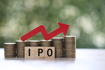 IPO ( Initial Public Offering), Red arrow on coins money and ipo word on natural green background, investment and business concept